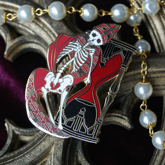 Enamel pin depicting a skeleton in vestal robes backed by a red sandglass timer. Behind the pin are pearls and a gothic window carving.