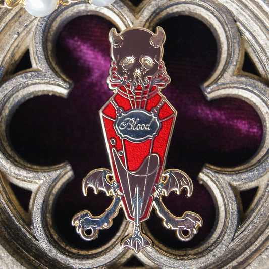 Enamel pin depicting a vial labelled 'blood'. Inside is a red liquid. The background is a carving of a gothic window.